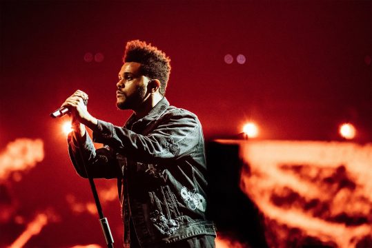 The Weeknd holding a microphone. 