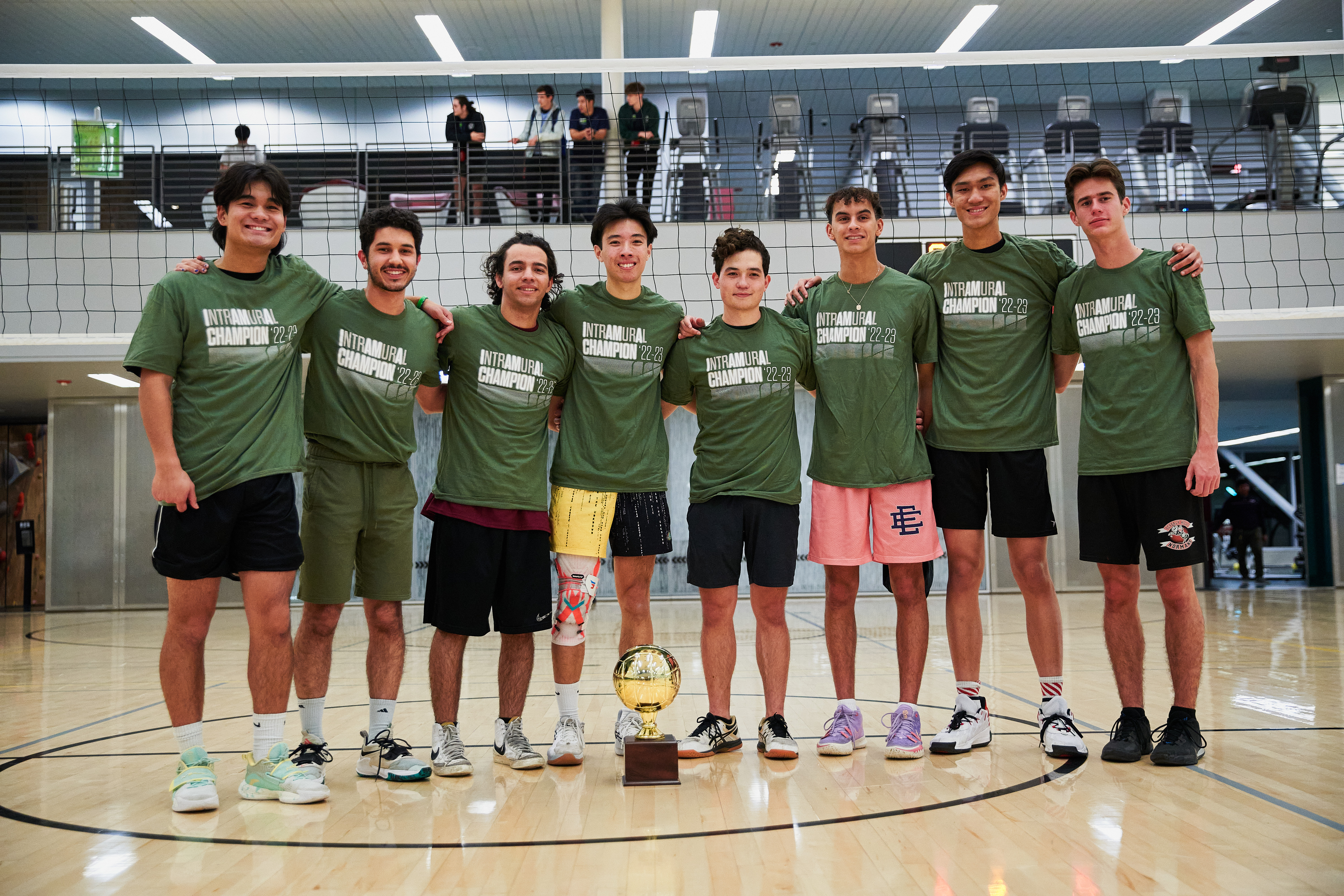 A group of students wearing Intramural Champion shirts smiling with a trophy.