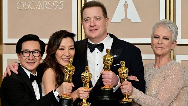 Ke Huy Quan, Michelle Yeoh, Brendan Fraser, and Jamie Lee Curtis hold up their Oscar trophies.  