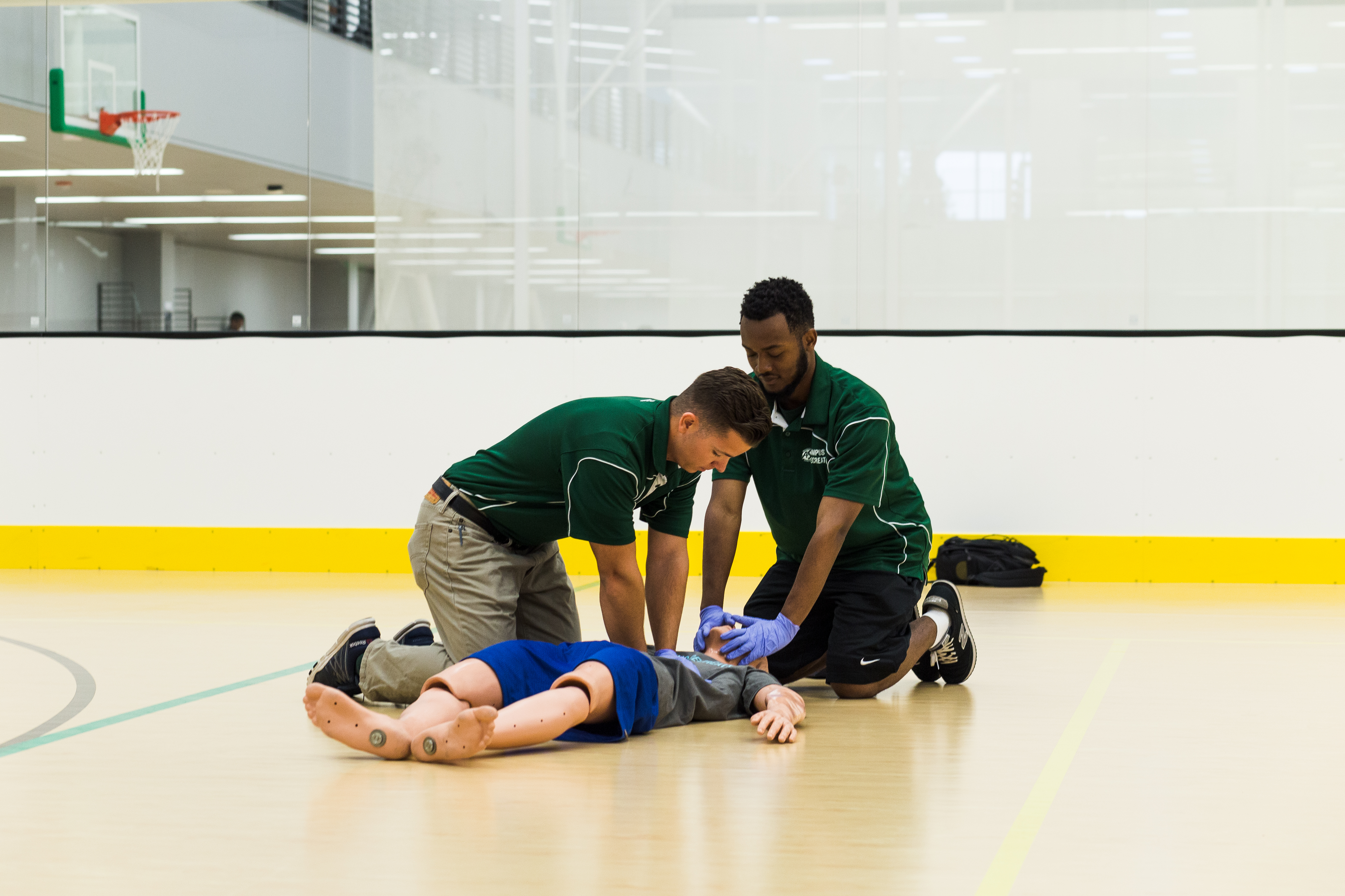 ASI student workers performing CPR on a practice dummy