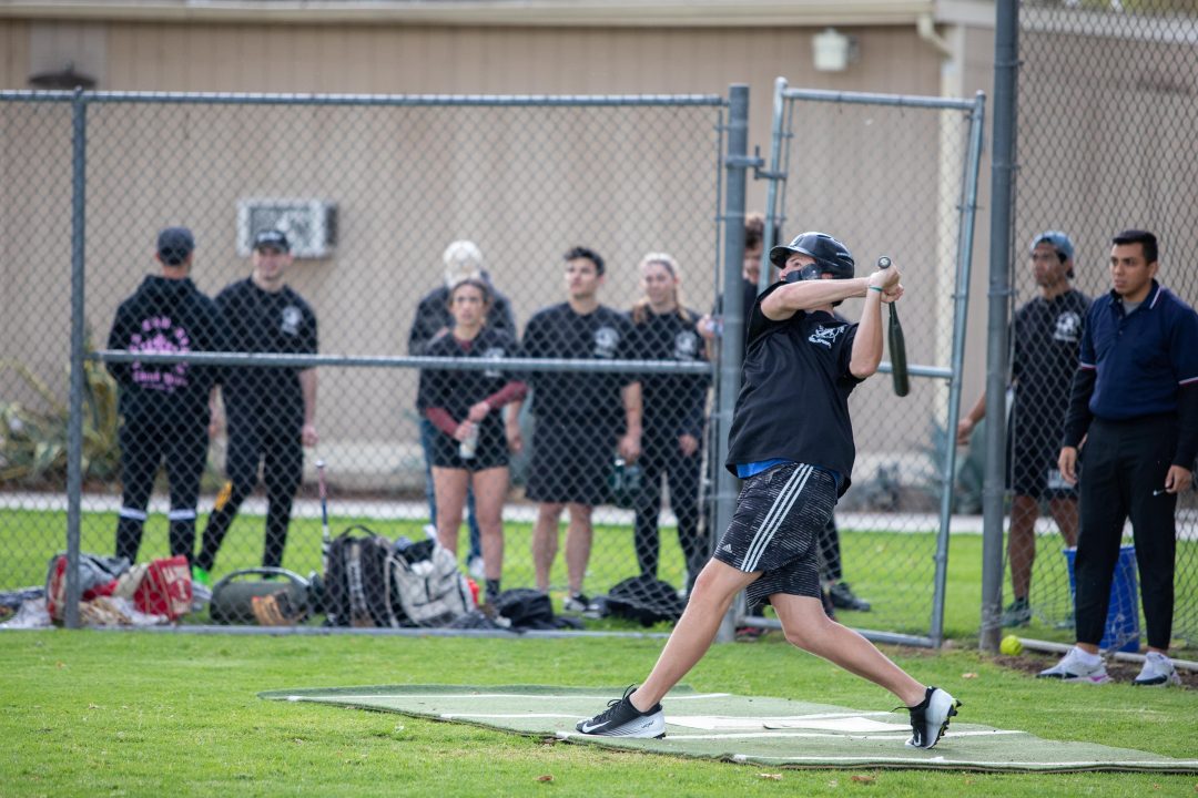 Student swinging the bat in a softball game. 