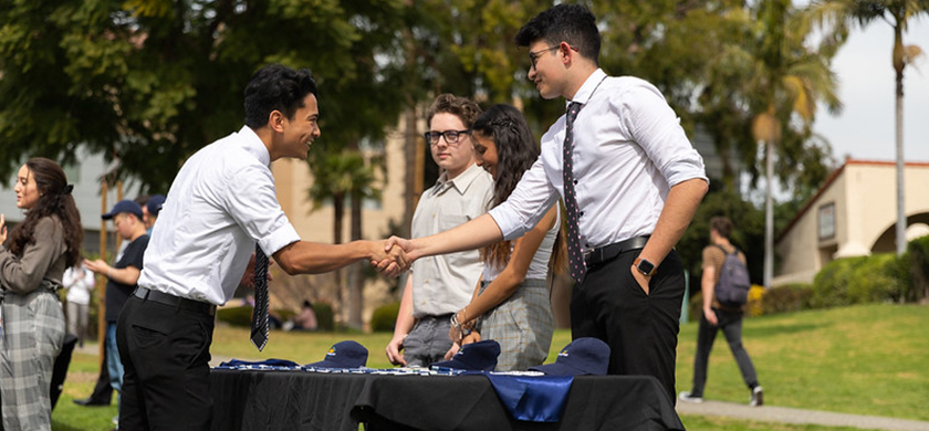 Student Government leader shaking hands with another student