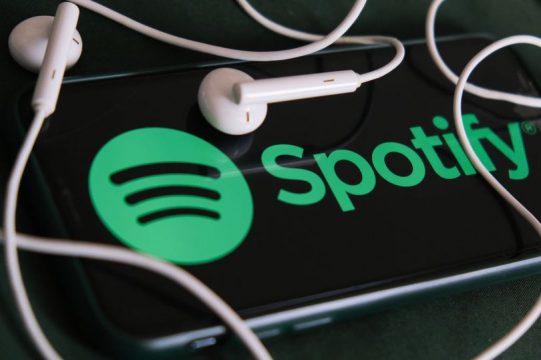 white earbuds around the Spotify logo