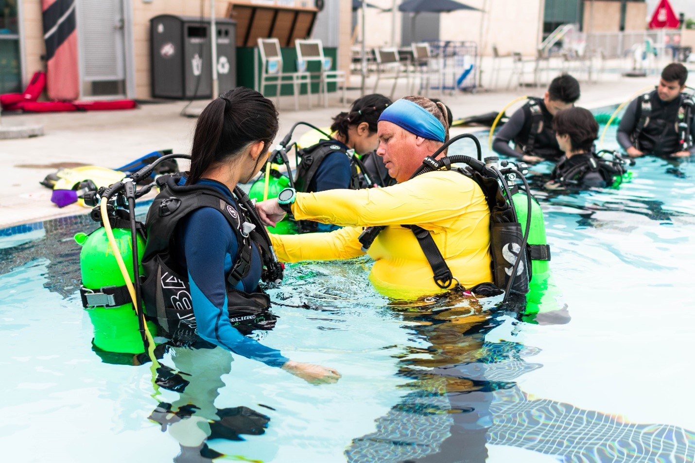 Instructor assisting a student with their scuba gear