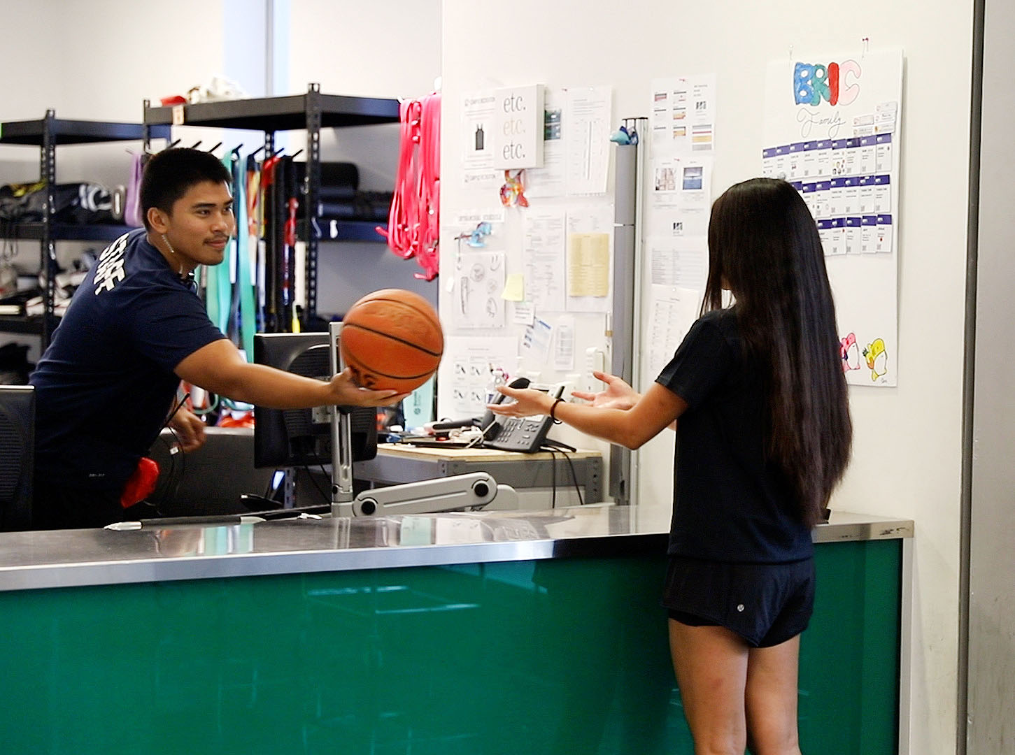 staff member handing a basketball to a student