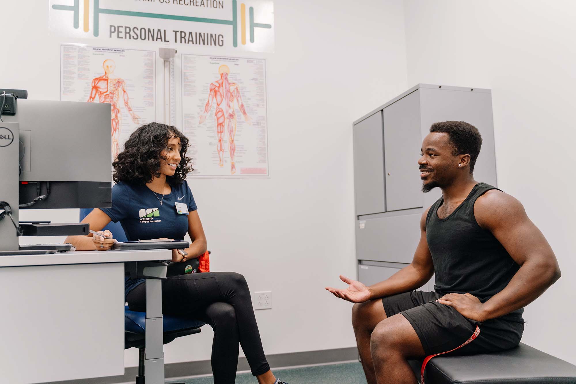 Personal trainer having a consultation with a student in an office