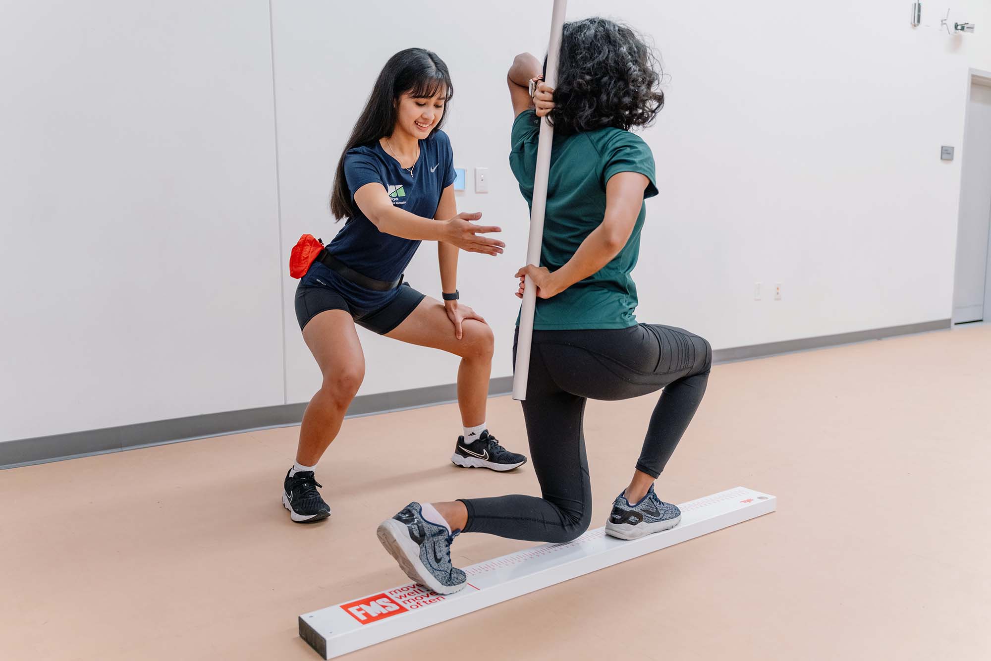 Personal trainer assisting a student with balance exercises