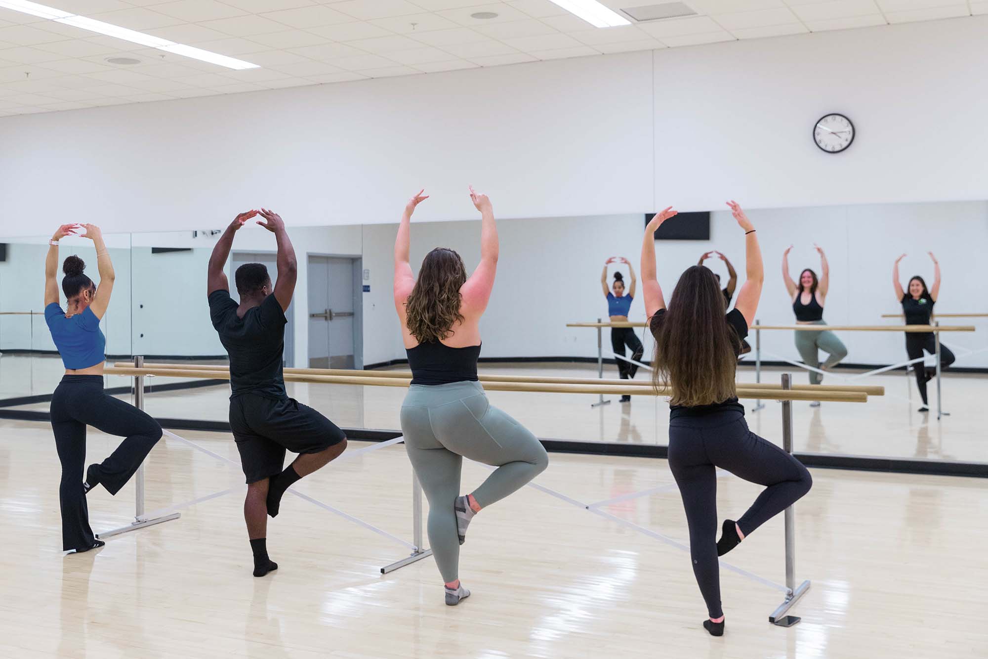 students following an instructor teaching in a ballet studio