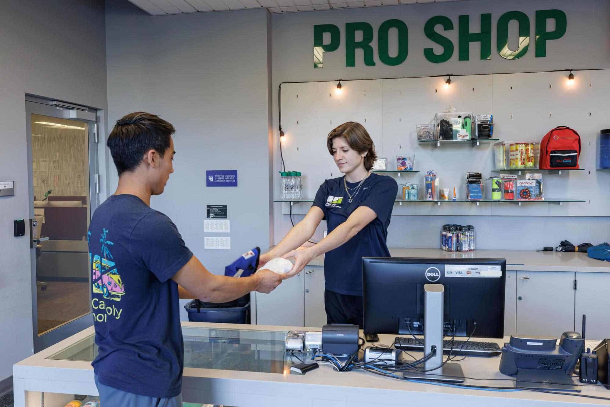 staff at BRIC Pro Shop giving item to a student